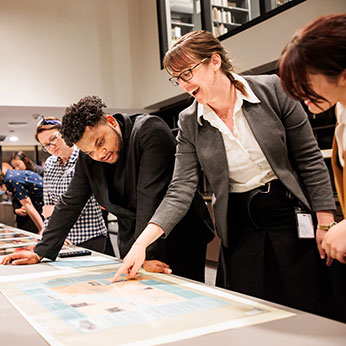 People looking at charts on a table. Links to Gifts of Life Insurance People looking at charts on a table. Links to Gifts of Life Insurance