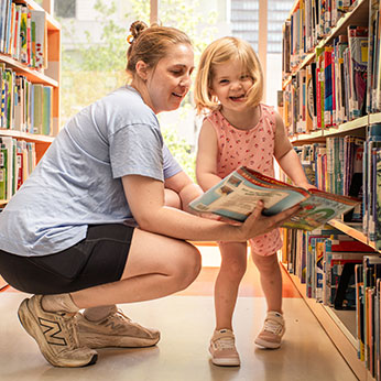 A mother and daughter looking at books. Links to Beneficiary Designations